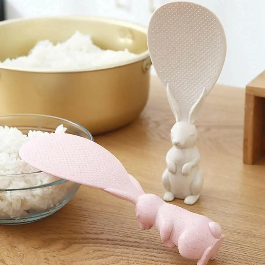 rabbit spoon one is standing other is laying down on bowl oof rice