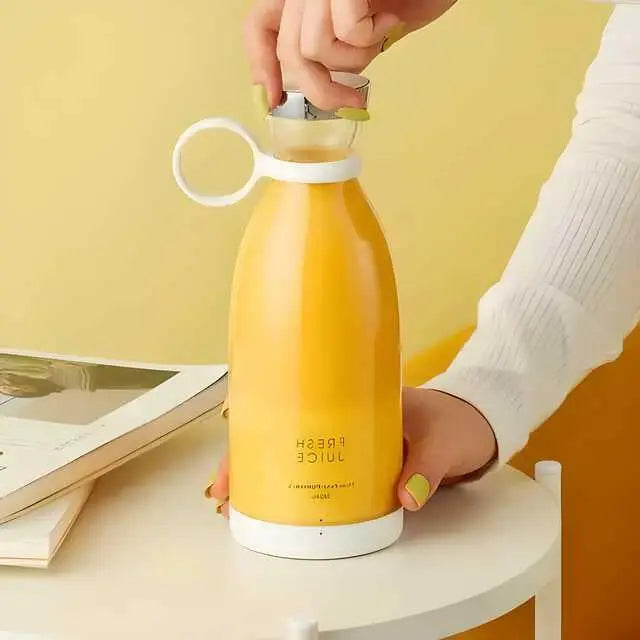 a woman hand opening the cap of portable mixer with juice in it