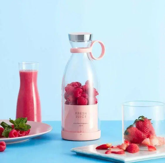 mixer is filled with strawberries and some strawberries on table 